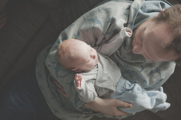 Draufsicht auf einen Vater, der seine schlafende neugeborene Tochter hält - IHF00011