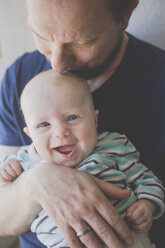 Father kissing his laughing baby daughter - IHF00017