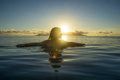 Französisch-Polynesien, Tahiti, Papeete, Frau genießt den Sonnenuntergang in einem Infinity-Pool - RUNF02060