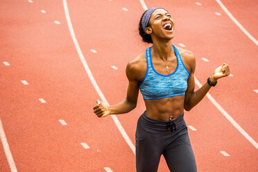 Happy Black athlete celebrating on track - BLEF03278