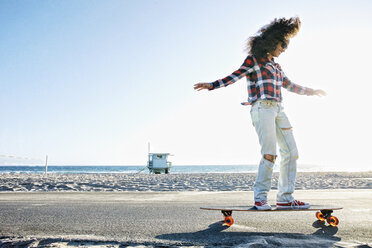 Hispanische Frau fährt Skateboard am Strand - BLEF03301