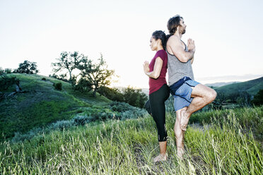 Pärchen übt Yoga auf einem Hügel - BLEF03318