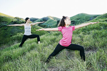 Mutter und Tochter üben Yoga auf einem Hügel - BLEF03332