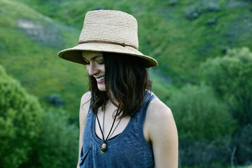 Lächelnde Frau mit Hut auf einem Hügel - BLEF03341