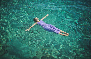 Kaukasische Frau im Kleid schwimmt im Wasser - BLEF03391