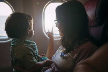 Mutter und kleine Tochter im Flugzeug schauen aus dem Fenster - GEMF02947