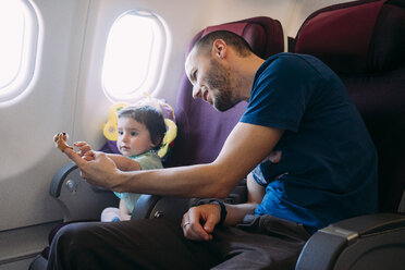 Father playing with his little daughter on airplane - GEMF02948