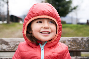 Portrait of happy toddler girl wearing red down jacket with hood - GEMF02962