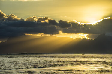 Französisch-Polynesien, Tahiti, Sonnenstrahlen brechen durch die Wolken über Moorea - RUNF02070