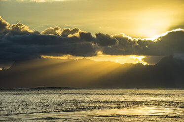 French Polynesia, Tahiti, sunrays breaking through the clouds over Moorea - RUNF02070