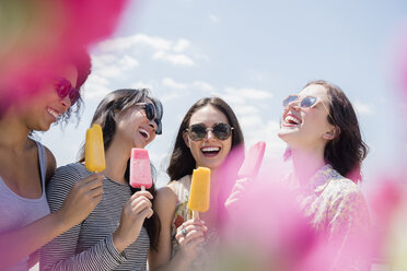 Lachende Frauen essen aromatisiertes Eis im Freien - BLEF03467