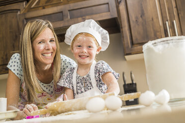 Caucasian mother and daughter covered in flour from food fight - BLEF03470