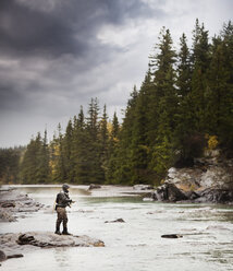 Caucasian man fishing at river - BLEF03483