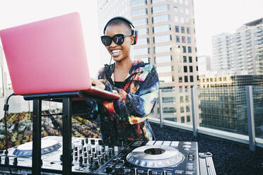 Smiling Black DJ on urban rooftop - BLEF03506