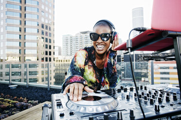 Smiling Black DJ on urban rooftop - BLEF03507