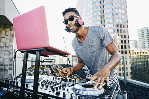 Smiling Black DJ on urban rooftop stock photo