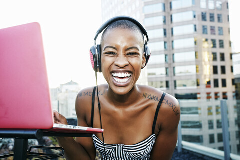 Portrait of Black DJ laughing on urban rooftop stock photo