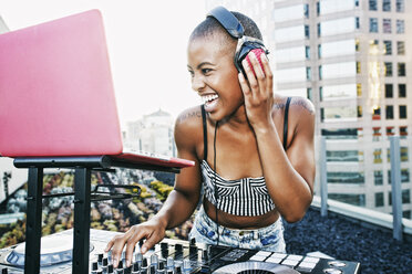 Black DJ laughing on urban rooftop - BLEF03514