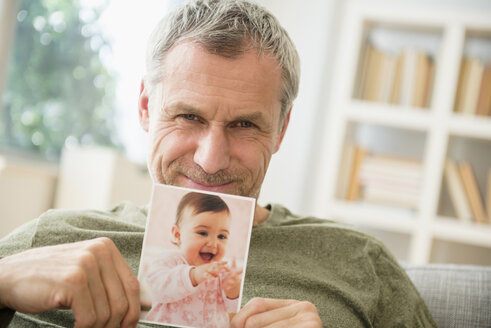 Stolzer Großvater zeigt Foto der kleinen Enkelin - BLEF03522