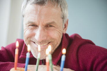 Älterer kaukasischer Mann lächelt über Geburtstagstorte - BLEF03531
