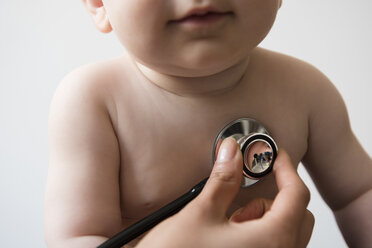 Doctor listening to chest of baby boy with stethoscope - BLEF03535