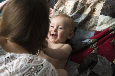 Kaukasische Mutter spielt mit ihrem kleinen Sohn auf einer Decke - BLEF03544