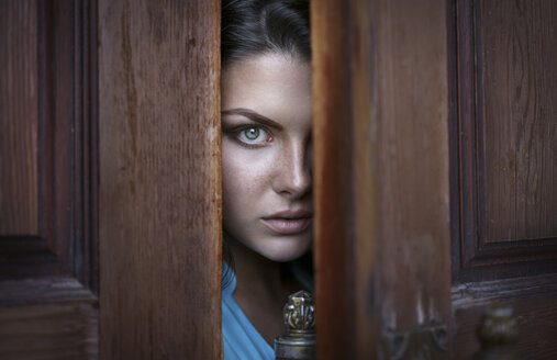 Kaukasische Frau späht durch die Tür - BLEF03549