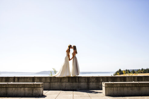 Caucasian brides kissing at waterfront - BLEF03626