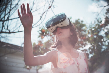 Mixed-Race-Mädchen benutzt Virtual-Reality-Brille im Freien - BLEF03656