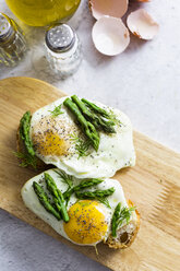 Slices of baguette garnished with fried eggs and Asparagus on a plate - GIOF06329