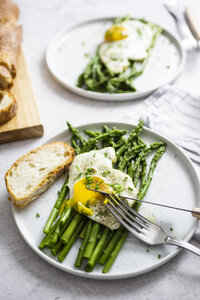 Spargel, Spiegeleier und Baguette auf Tellern - GIOF06335