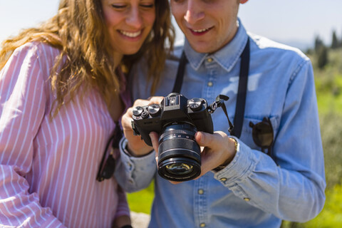 Ein Paar betrachtet die Bilder auf seiner Digitalkamera, lizenzfreies Stockfoto