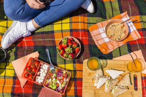 Junge Frau bei einem Picknick mit gesundem Essen in einem Park - MGIF00452