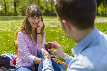 Young man proposing to his girlfriend in a park - MGIF00474