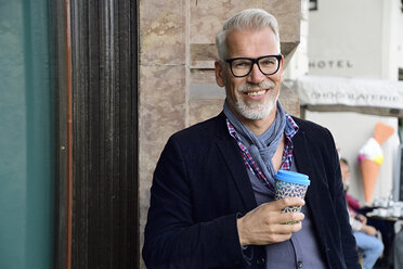 Portrait of smiling mature man with reusable bamboo cup in the city - ECPF00755