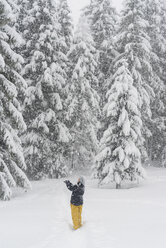 Finnland, Kuopio, Frau fängt Schneeflocken im Winterwald - PSIF00261
