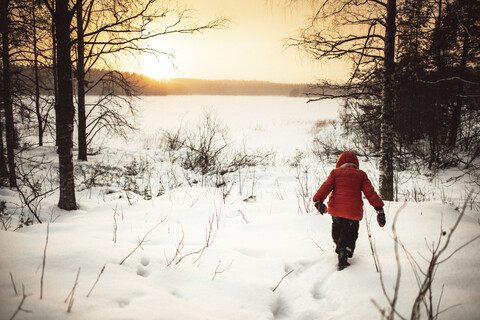 Finnland, Kuopio, Kleinkind Mädchen zu Fuß in Winterlandschaft bei Sonnenuntergang, lizenzfreies Stockfoto