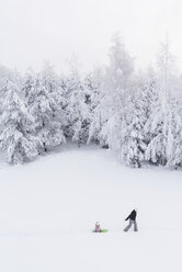 Finnland, Kuopio, Mutter und Tochter mit Schlitten im Winterwald - PSIF00267