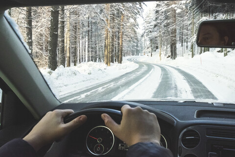 Finnland, Kuopio, Frau fährt Auto in Winterlandschaft, lizenzfreies Stockfoto