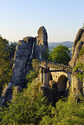 Deutschland, Sachsen, Elbsandsteingebirge, Blick auf die Bastei-Felsformation bei Sonnenaufgang mit Basteibrücke - RUEF02197