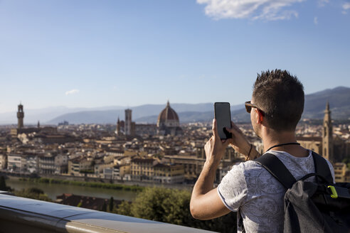 Mann, der mit seinem Smartphone ein Foto von Florenz macht, Florenz, Italien - MAUF02454