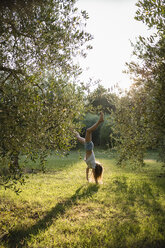 Mädchen macht Handstand auf einer Wiese, Toskana, Italien - OJF00349