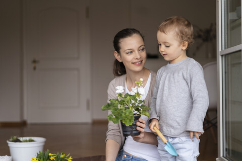 Mutter und Tochter pflanzen gemeinsam Blumen zu Hause, lizenzfreies Stockfoto