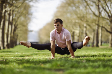 Junger Mann macht gymnastische Akrobatik in einem Stadtpark - JSMF01083