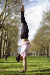 Junger Mann macht einen Handstand in einem Stadtpark - JSMF01086