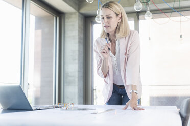 Businesswoman working in conference room in office - UUF17504