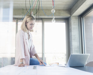 Businesswoman working in conference room in office - UUF17508