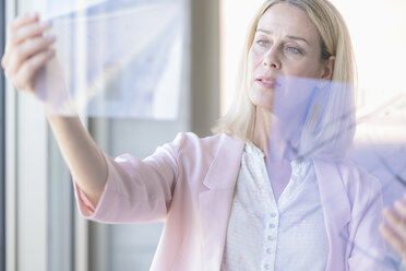 Businesswoman holding transparent foil - UUF17533