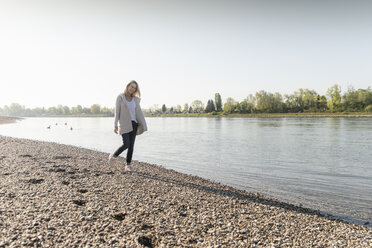 Glückliche reife Frau beim Spaziergang am Flussufer - UUF17572