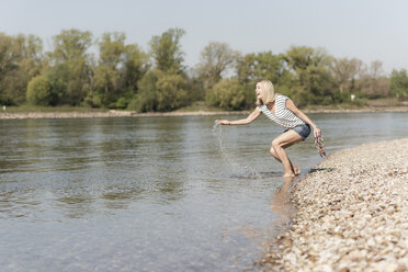 Glückliche reife Frau beim Planschen in einem Fluss - UUF17589